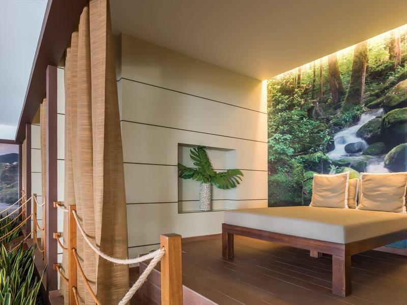 Moderner Balkon mit Holzgeländer, Pflanzen und Wandbild eines Wasserfalls im Wald.