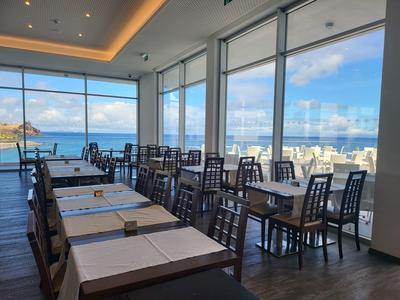 Modernes Restaurant mit großen Fenstern und Blick auf das Meer