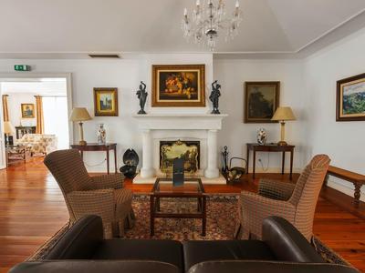 Gezellige hotel lounge met fauteuils, open haard en kunst aan de muren.