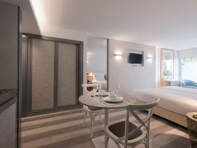 Heller Raum mit rechteckigem Esstisch, zwei Stühlen, Bett, Fenster und moderner Einrichtung.