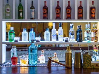 Polička s různými lahvemi alkoholických nápojů za barem