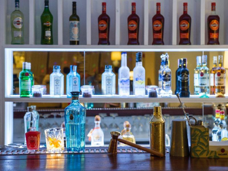 Polička s různými lahvemi alkoholických nápojů za barem