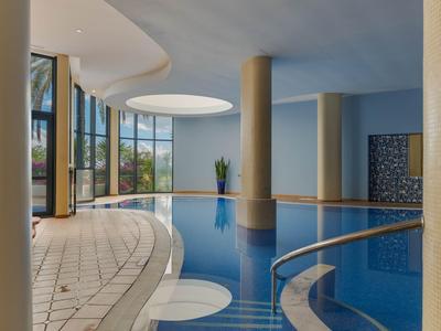 Moderner Innenpool mit großem Rundfenster und Säulen in einem Hotel.