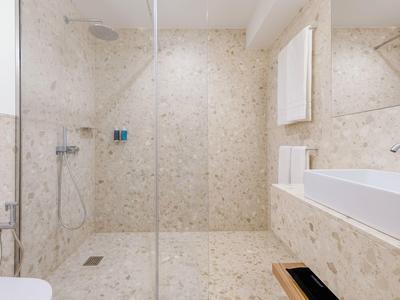 Lichte badkamer met inloopdouche, grote spiegel en moderne wastafel