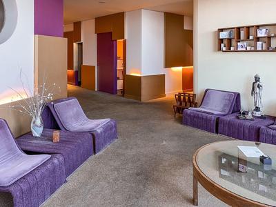 Przytulny salon z fioletowymi fotelami i stolikiem w hotelu