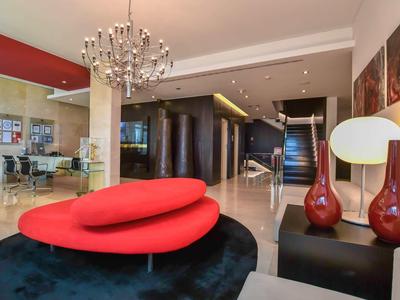 Espace de hall d'hôtel moderne avec canapé rouge design et lustre.