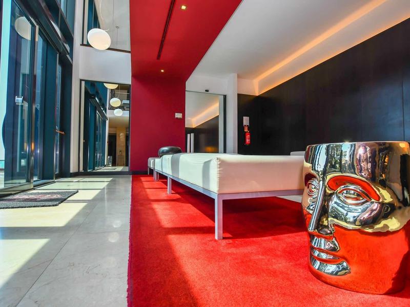 Espace de hall d'hôtel moderne avec tapis rouges et tabouret argenté brillant