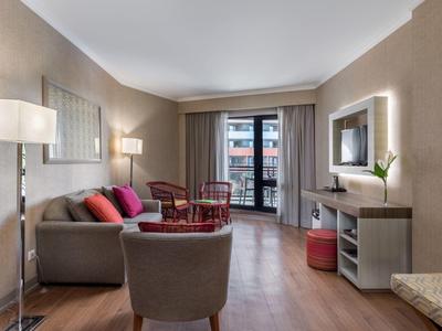 Modern living room with sofa, armchairs, and access to a balcony.