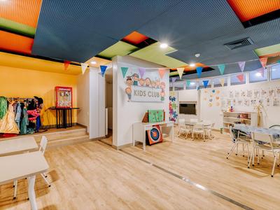 Bright kids' playroom with colorful walls, tables, chairs, and toys