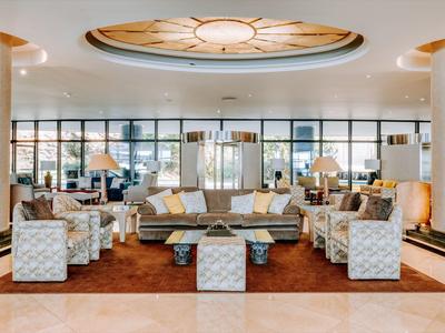 Bright hotel lobby with comfortable seating and large ceiling window