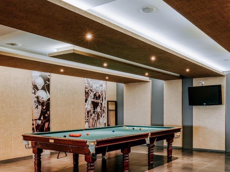 Elegant communal room with pool table, LED ceiling lights, and wall decorations.
