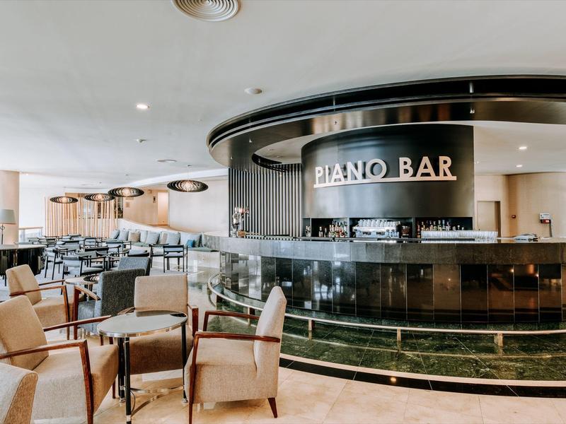Elegant hotel bar with piano and comfortable seating in bright ambiance