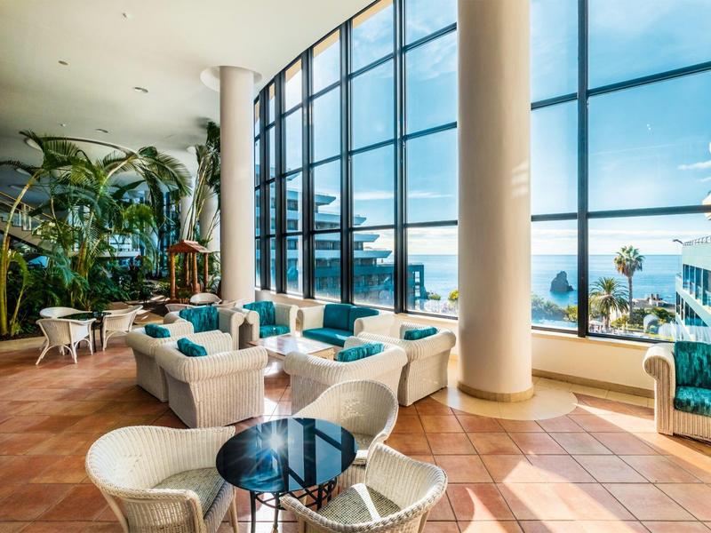 Hotel lounge with comfortable seating and large windows overlooking the sea