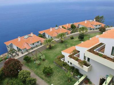 Hotelanlage mit roten Dächern an einer Klippe mit Blick auf das blaue Meer.