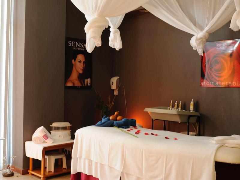 Accogliente stanza per massaggi con lettino, finestra Velux e illuminazione calda.