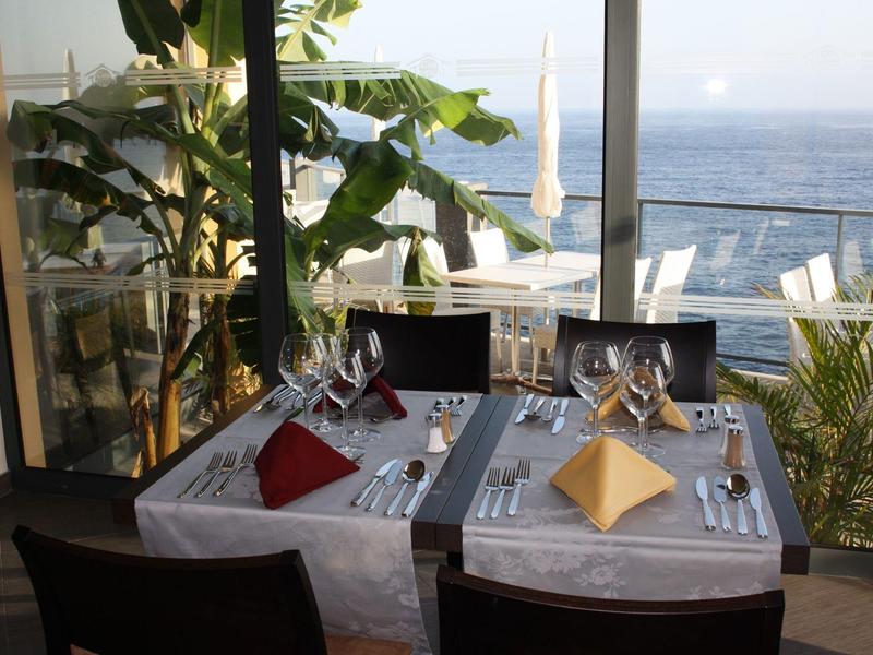 Elegancko nakryty stół w restauracji z widokiem na morze na tarasie.