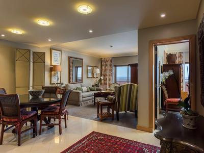 Espace salon d'hôtel chaleureux et élégant avec fauteuils et table à manger.