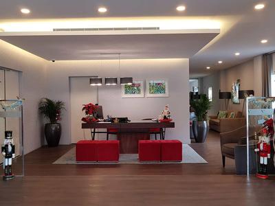 Modern eingerichtete Hotellobby mit weißen Wänden, roten Sitzbänken und großer Vase.