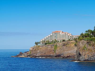 Hotel su una scogliera con vista sul mare blu e cielo limpido