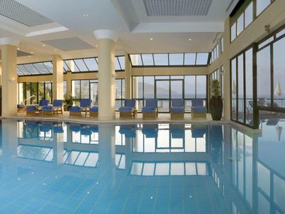 Grande piscina coperta con finestre panoramiche che dominano il paesaggio urbano.