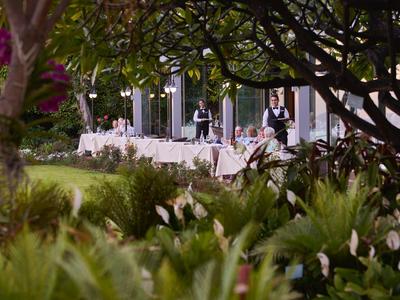 Terrazza del ristorante con tavoli apparecchiati e vista tra piante verdi
