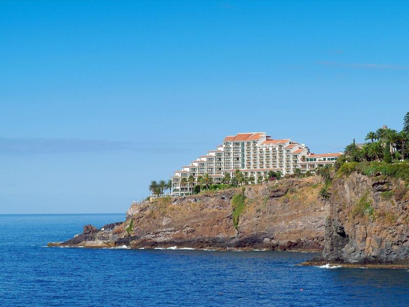 Hotel su una scogliera con vista sul mare blu e cielo limpido
