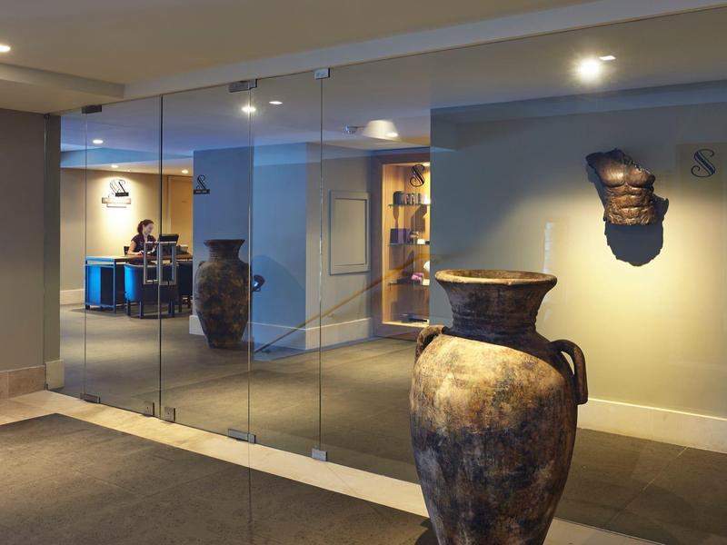 Grande vaso antico nel corridoio dell'hotel con parete a specchio e illuminazione soffusa