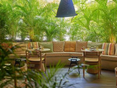 Pohodlná venkovní lounge s posezením, rostlinami a tlumeným osvětlením v hotelu.