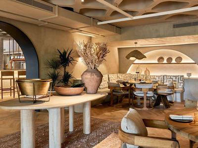 Elegantní, teple osvětlená hotelová restaurace s moderním nábytkem a útulnou atmosférou.