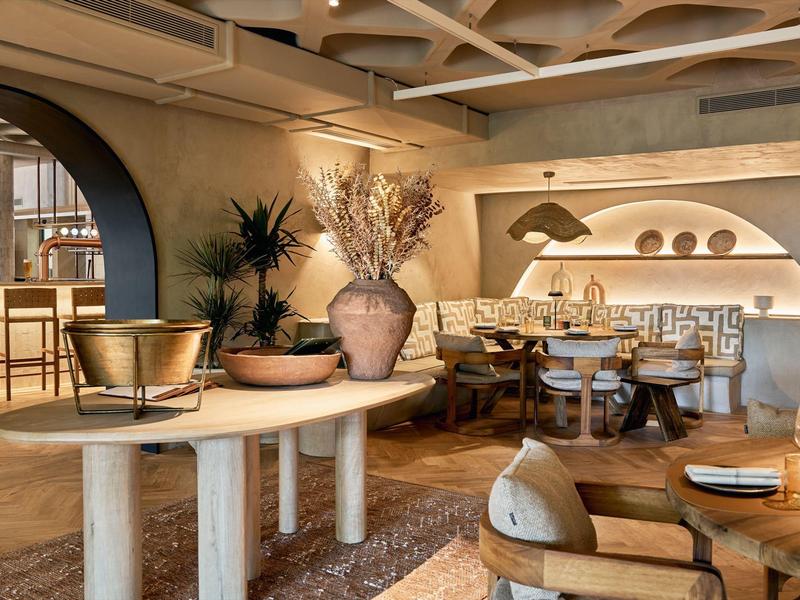 Elegantní, teple osvětlená hotelová restaurace s moderním nábytkem a útulnou atmosférou.