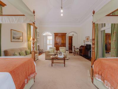 Geräumiges Schlafzimmer mit Doppelbett, Holzmöbeln, Teppichboden und weichen Vorhängen.