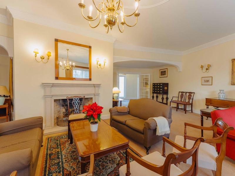 Gemütliches Wohnzimmer mit Kamin, braunen Sofas, Holz-Möbeln und warmem Licht.