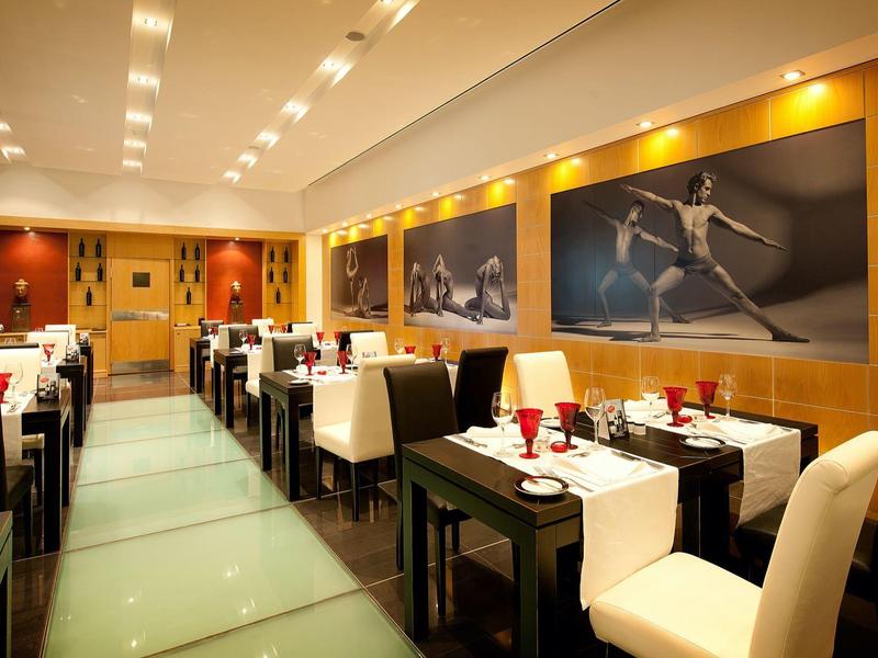 Elegancka restauracja z nowoczesnym wystrojem, białymi dekoracjami stołów i ciepłym oświetleniem.