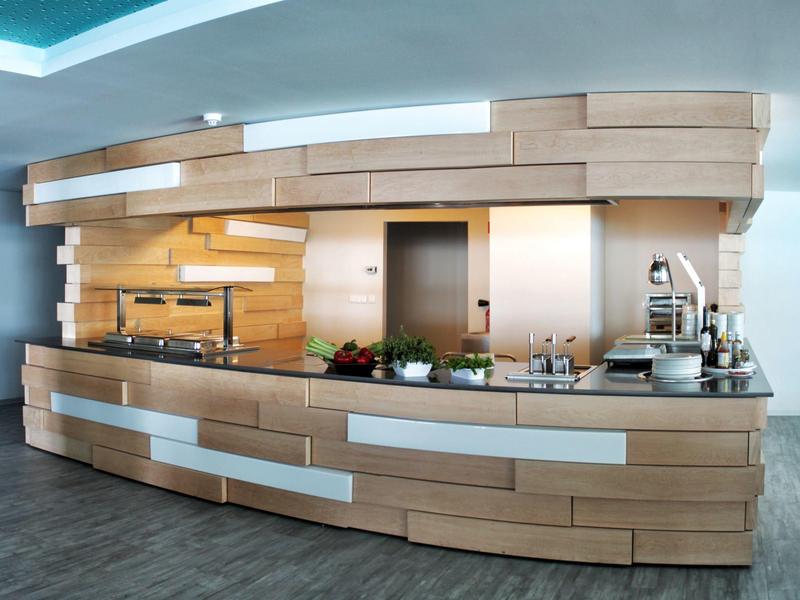 Area reception moderna con pannellature in legno e piante decorative in un hotel.