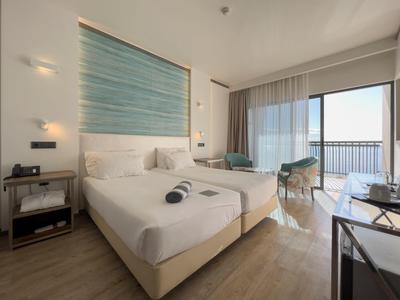 Modernes, helles Doppelzimmer mit zwei Betten, Meerblick, Holzboden und minimalistischer Einrichtung.