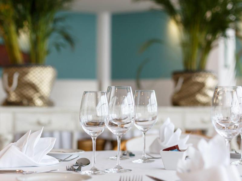 Elegante tafel gedekt met wijnglazen, wit servies en gevouwen servetten in het restaurant.