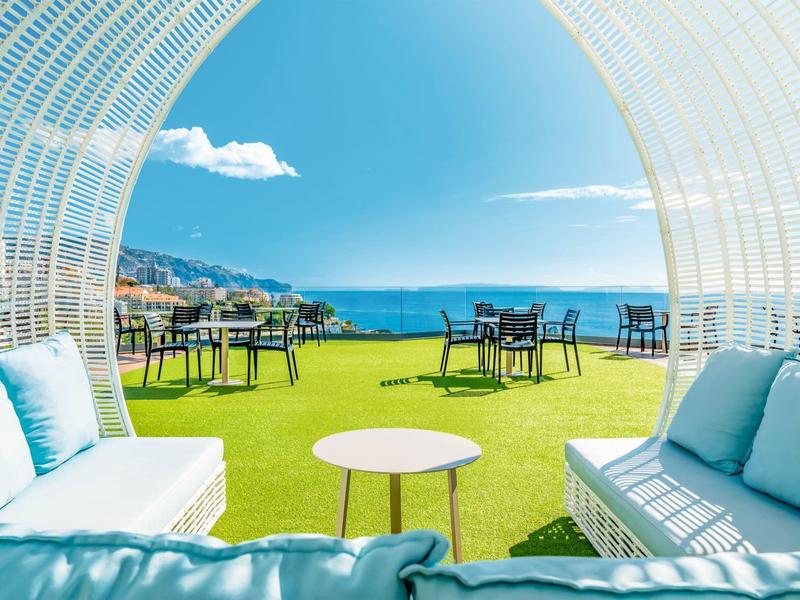 Gezellige zithoek met zeezicht op een terras bij helder weer