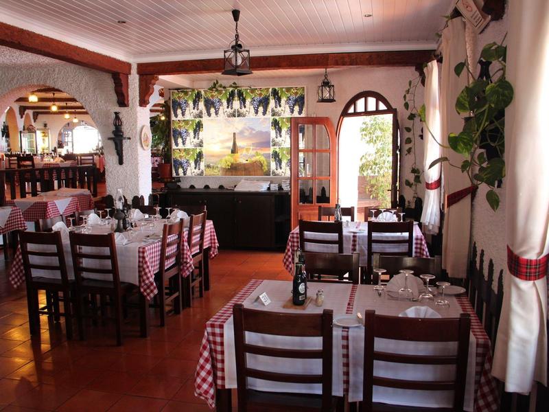 Ristorante accogliente con tovaglie a scacchi, mobili in legno e illuminazione calda.