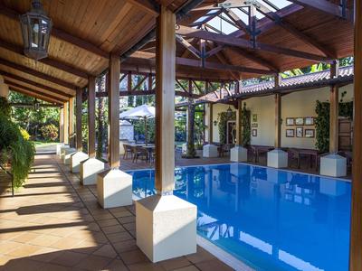 Area piscina coperta con soffitto in legno e posti a sedere in un hotel.