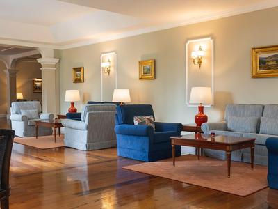 Helles Hotel-Lounge mit bequemen Sesseln, Sofas und Holzböden.