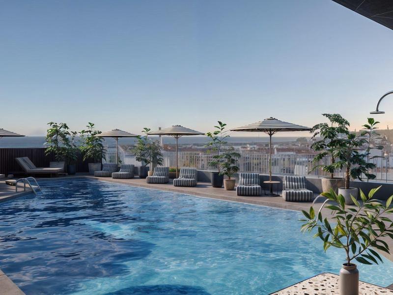 Dachterrassenpool mit Liegestühlen und Sonnenschirmen bei klarem Himmel