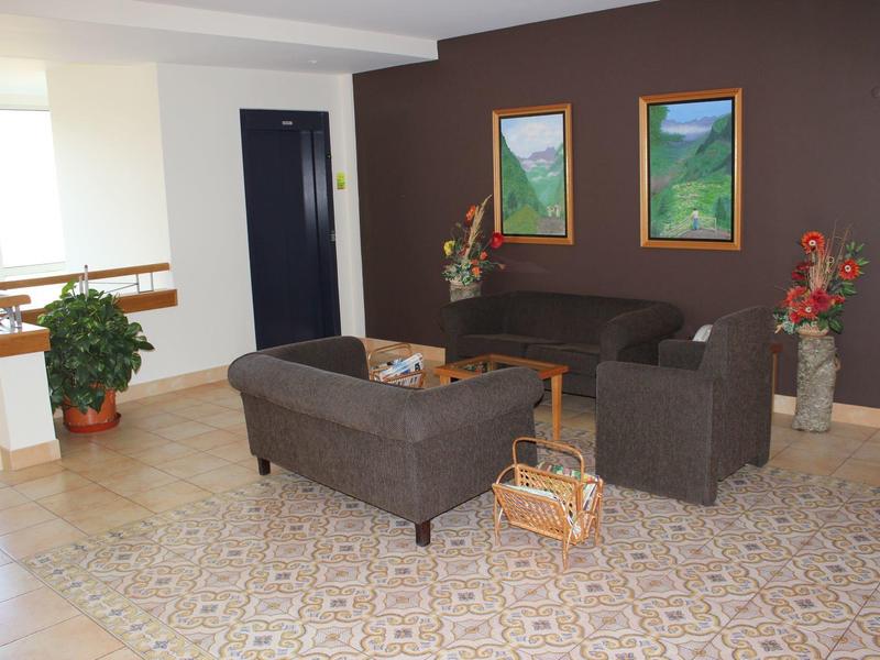 View from a hotel with pool overlooking a mountain valley with village in the distance.