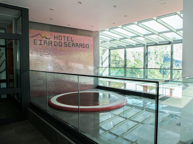 Interior view of a hotel with a modern hot tub and large window wall