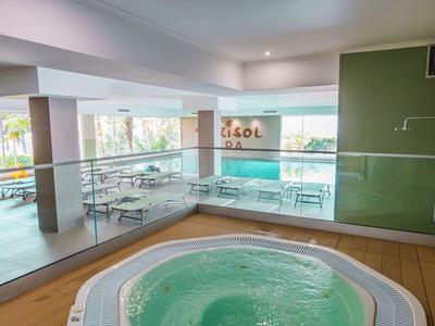 Moderner Whirlpool mit Panoramablick auf Terrasse und Gartenbereich in einem Hotel.