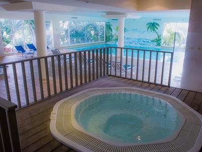 Gezellige binnenjacuzzi met uitzicht op het zwembadgebied en tropische decoraties.