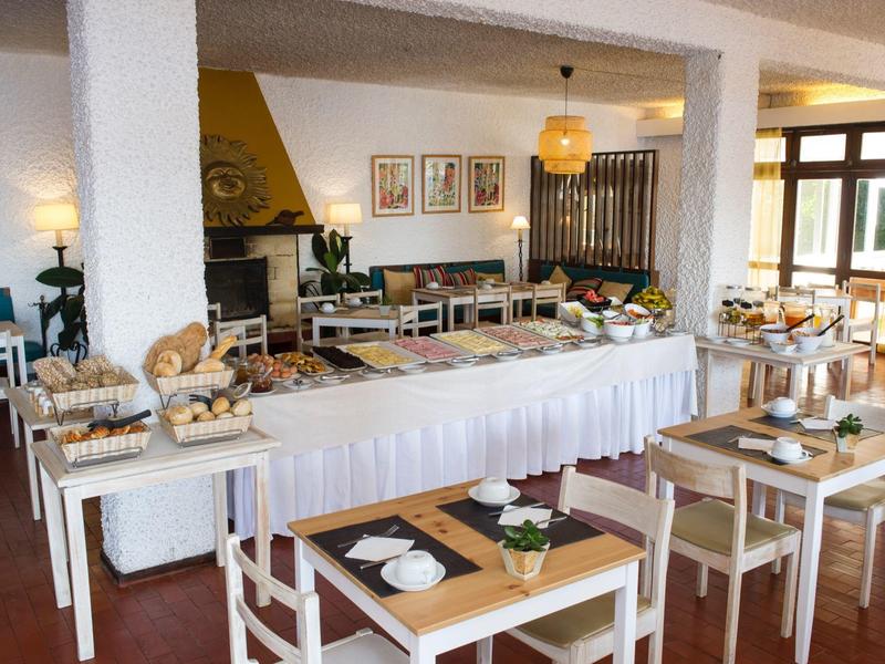 Buffet met gebak en zitgedeelte in een lichte, gezellige eetkamer.