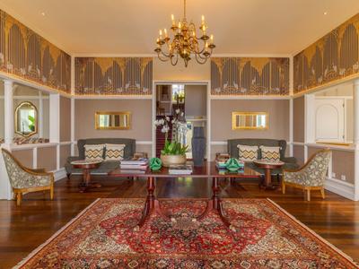 Eleganter Hotellobby-Bereich mit antiken Möbeln und rotem Teppich.