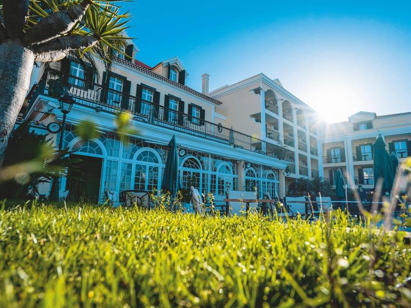 Hotelgebäude mit Rasen im Vordergrund bei Sonnenschein
