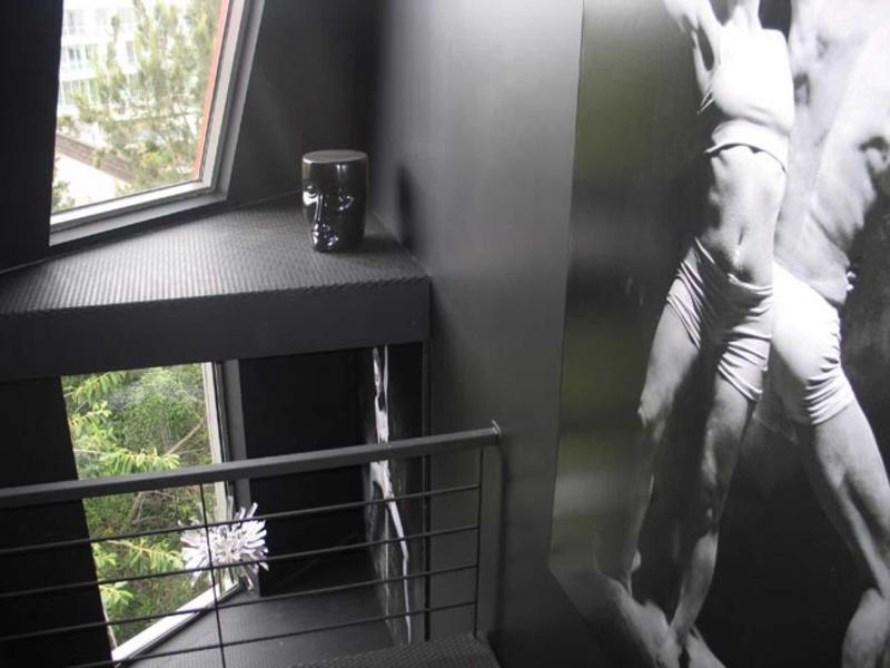 Corridoio d'hotel moderno con murale in bianco e nero e finestra con vista sul verde.