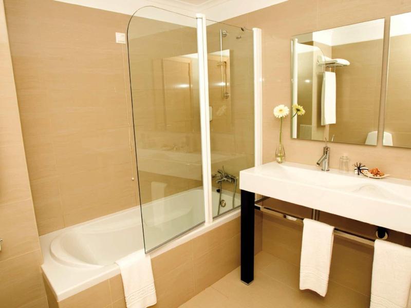 Bagno moderno con vasca da bagno, lavabo e grandi specchi.